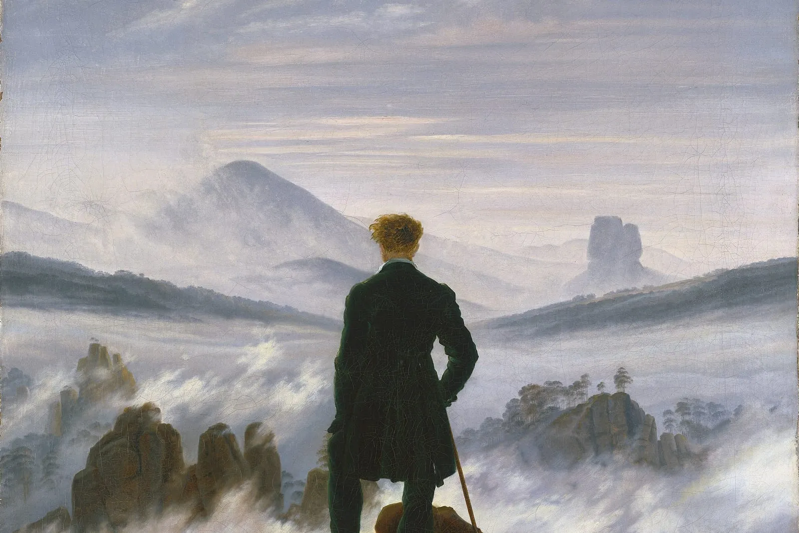 Pintura de Caspar David Friedrich: um homem de casaco escuro, de costas, no alto de uma rocha, olha um mar de névoa de onde saem picos e montanhas ao longe.